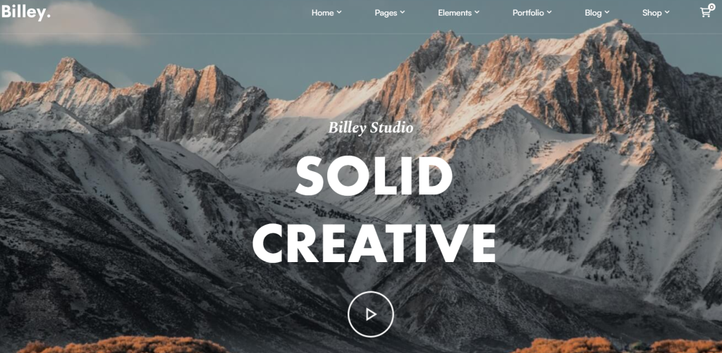 Billey WorsPree Theme A website banner showcasing 'SOLID CREATIVE' text for Billey Studio over a background of snow-capped mountain peaks at dusk.